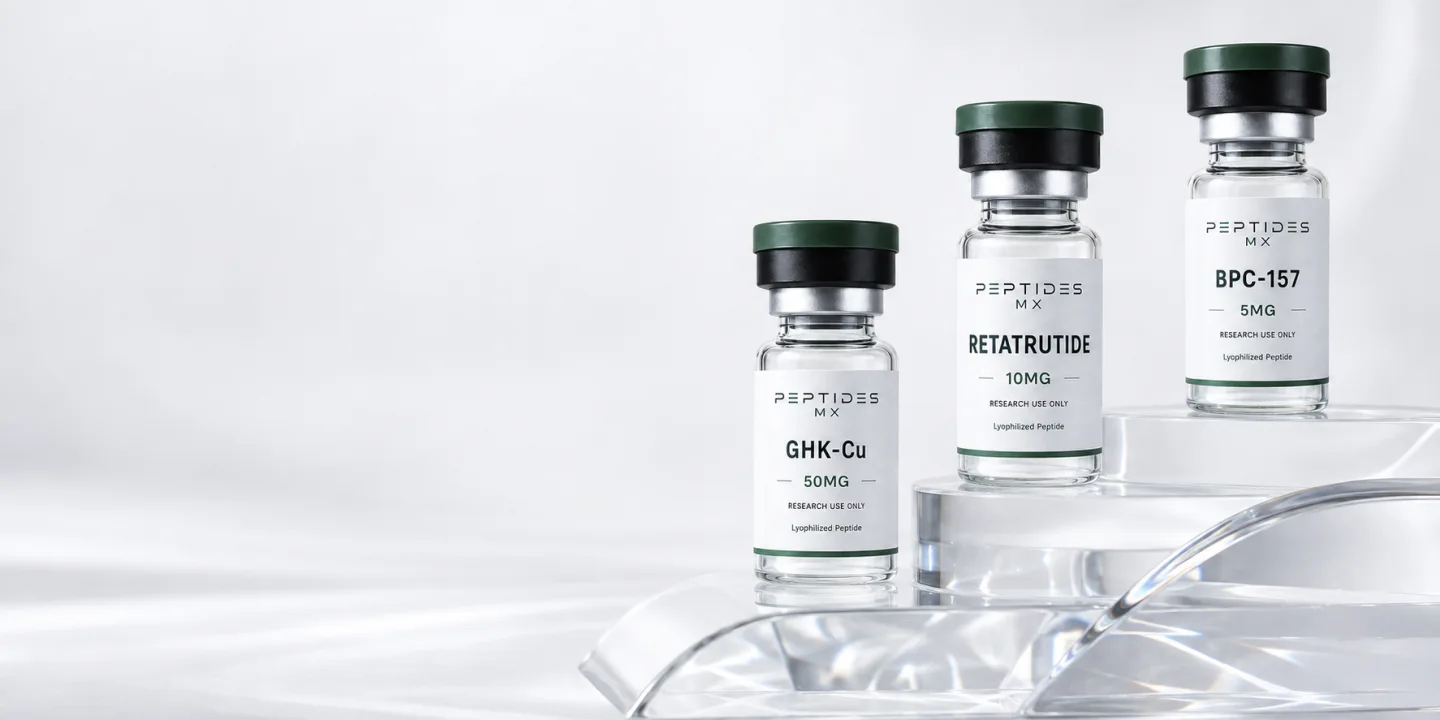 Viales Peptides MX de Retatrutide 10 mg, GHK-Cu 50 mg y BPC-157 5 mg sobre una base de cristal.